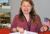 Sally Romero proudly shows her U.S. citizenship certificate and her certificate from the Peterson School of Facilities.