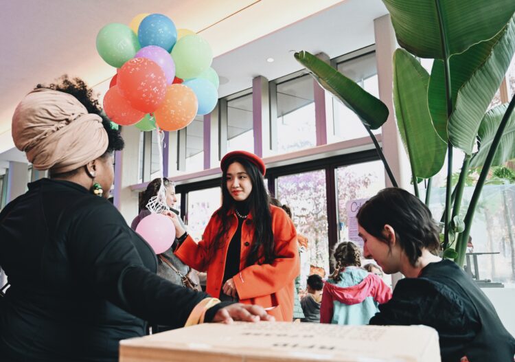 Artist Tianyuan (Margaret) Zheng (in red) engages with participants during Bright Spot: Pie with Wide Tim