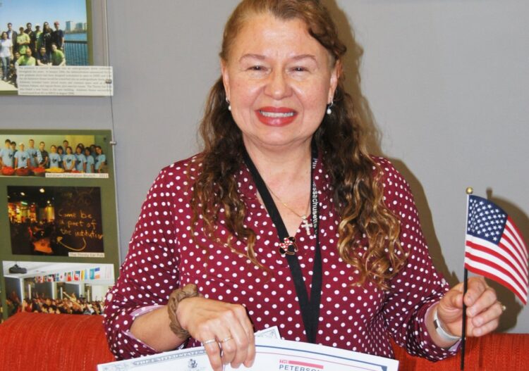 Sally Romero proudly shows her U.S. citizenship certificate and her certificate from the Peterson School of Facilities.